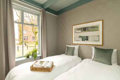 twee bedden in een kamer met een raam bij Brinkzate - De Brink in Dwingeloo