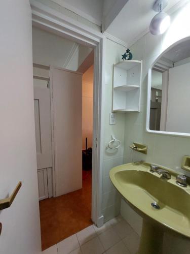 a bathroom with a green sink and a mirror at Tu Lugar en Mardel in Mar del Plata
