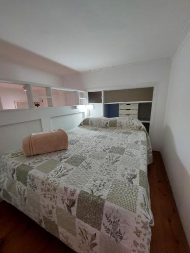a bedroom with a bed with a quilt on it at Tu Lugar en Mardel in Mar del Plata