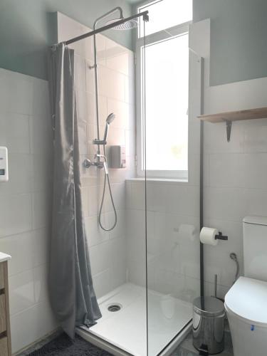 a shower with a glass door in a bathroom at The Venue Hostel Boutique in Valencia
