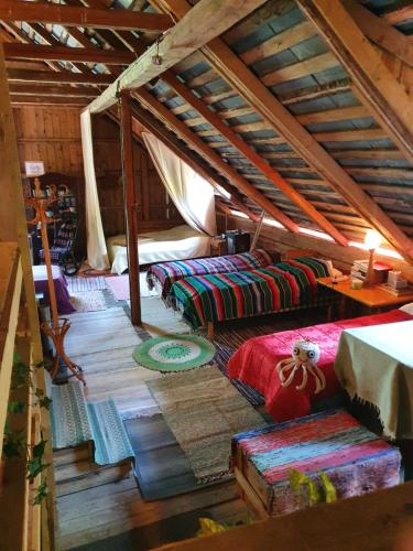 an attic room with three beds and a table at Villa Puistola Vinttimajoitus in Hämeenlinna