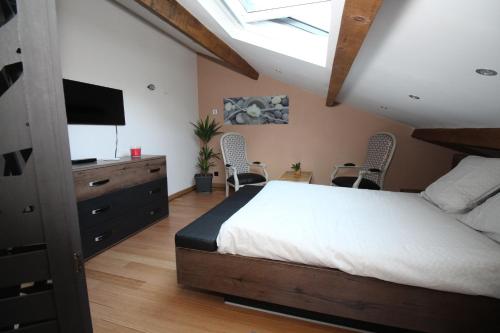 - une chambre avec un lit, une télévision et des chaises dans l'établissement Au cœur de la Roque d'Anthéron - Aux portes du Lubéron, à La Roque-dʼAnthéron