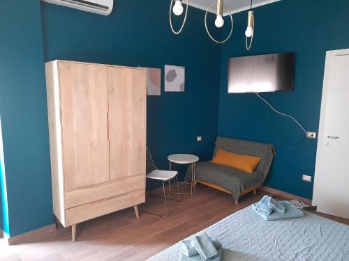 a bedroom with a blue wall with a bed and a chair at Casa vacanze G&G in Naples