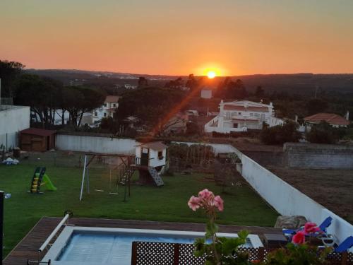 a view of a sunset from a house with a pool at Quinta dos Passarinhos in Nadadouro