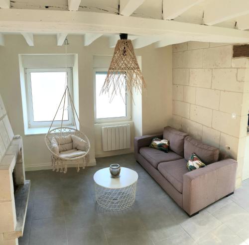 uma sala de estar com um sofá e um baloiço em Logis de charme en Touraine em Sainte-Maure-de-Touraine