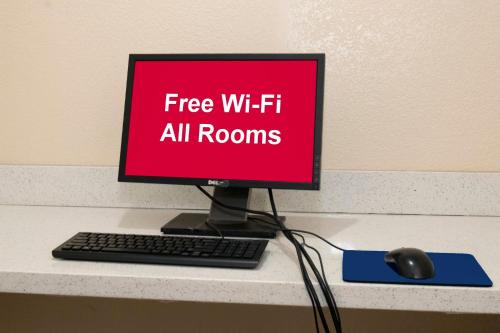 a computer monitor and a keyboard and mouse on a desk at Red Roof Inn High Point - University in Westwood