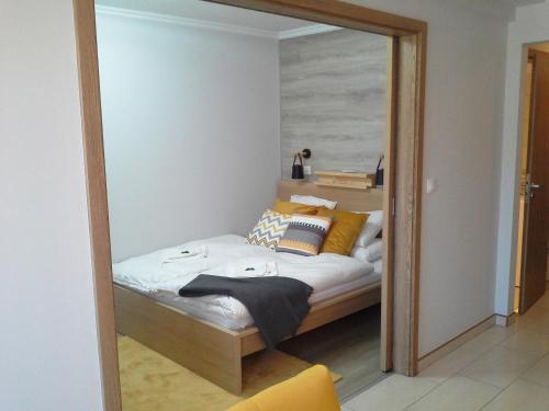 um reflexo de espelho de uma cama num quarto em Alexandra Apartment Hajdúszoboszló - Chic Flat em Hajdúszoboszló