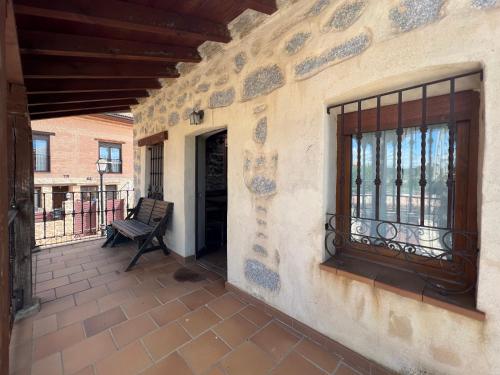 a patio with a bench and a window on a building at Casa La Colmena Ávila in Avila