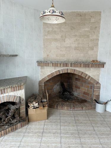 Habitación con chimenea de ladrillo y lámpara de araña. en Casa Almendro, en Jumilla