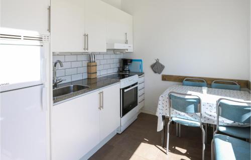 a kitchen with a sink and a table with chairs at 3 Bedroom Gorgeous Home In Löttorp in Löttorp