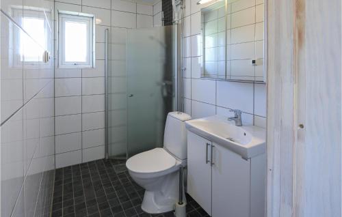 een witte badkamer met een toilet en een wastafel bij Cozy Home In Lttorp With Kitchen in Löttorp