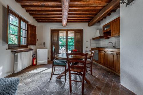 a kitchen with a table and chairs in a room at Podere Mezzastrada - Place of Charme in Fiano