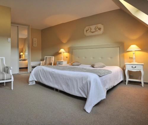 a bedroom with a large bed and two chairs at Hotel Relais Saint Jean Troyes in Troyes