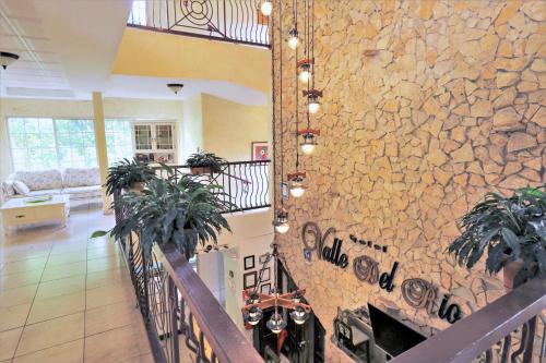 a stone wall in a living room with plants at Hotel Valle del Rio in Boquete