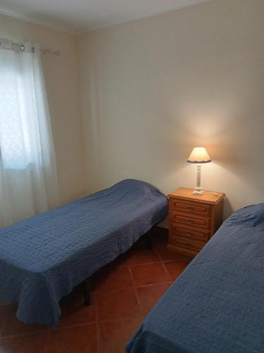 ein Schlafzimmer mit 2 Betten und einer Lampe auf einer Kommode in der Unterkunft Casa do Poço in Quinta do Anjo