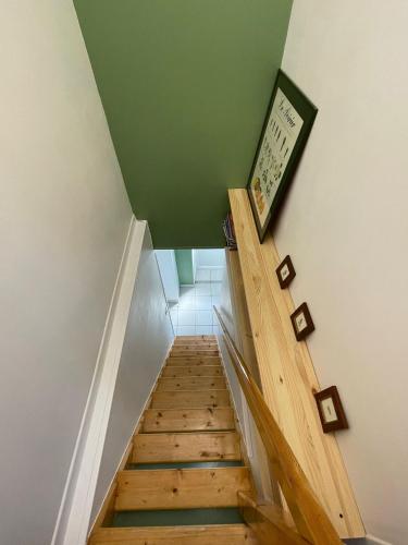 un escalier avec un plafond vert et des marches en bois dans l'établissement La Tiote Maison, à Fiennes