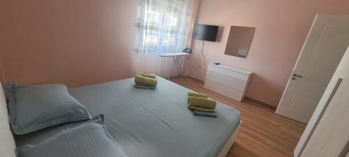 a bedroom with a bed with two yellow cushions on it at Beach View Apartment, Golem Durres in Durrës