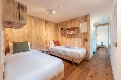 1 Schlafzimmer mit 2 Betten und Holzwänden in der Unterkunft stuub todtnauberg in Todtnauberg