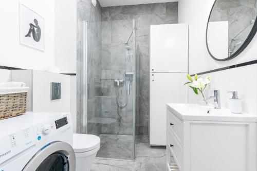 biała łazienka z prysznicem i pralką w obiekcie LIKE LAKES Ukiel Park 31 Free Parking FV w Olsztynie