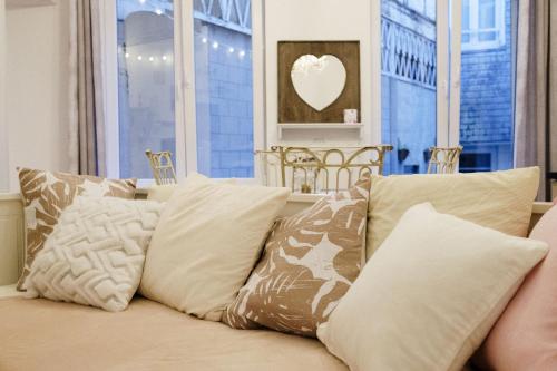 a couch with pillows in front of a window at L'hôtel de Police - Topdestination-Spa in Spa