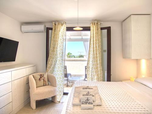 ein Schlafzimmer mit einem Bett und einem Stuhl und einem Fenster in der Unterkunft Ideal Rooms in Porto Cesareo