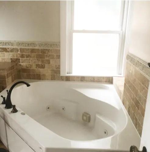 a white bath tub in a bathroom with a window at Large Suite w/ Private Bath,great location in Boston