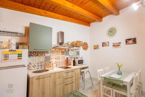 kuchnia z lodówką i stołem z krzesłami w obiekcie Family Home w mieście Quartu SantʼElena