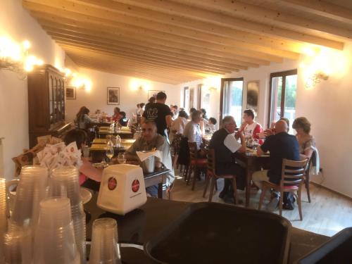 a group of people sitting at tables in a restaurant at Agriturismo La Fornace centro ippico in Como