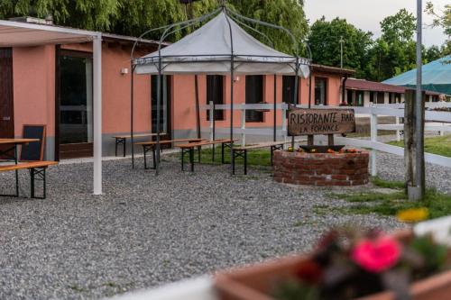 a pavilion with tables and a sign in front of a building at Agriturismo La Fornace centro ippico in Como