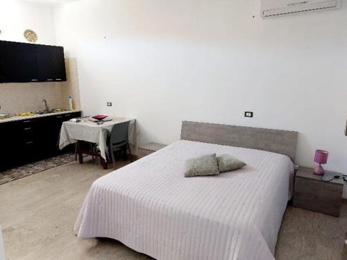 - une chambre avec un lit blanc, une table et une table dans l'établissement Casa vacanze Poma, à Custonaci
