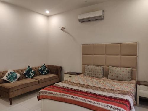 ein Schlafzimmer mit einem Bett und einem Sofa in der Unterkunft Royal Family Suite E-11 Only for Families Islamabad in Islamabad