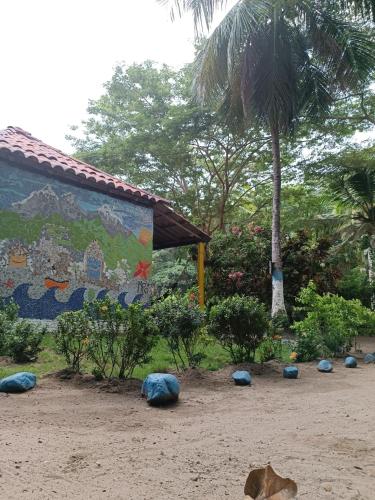 a mural on the side of a building with a palm tree at Cabañas San Sebastian in Palomino