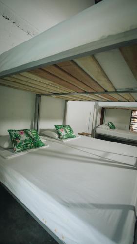 two bunk beds with green and white pillows on them at Makenke Hostel By Los Colores Ecoparque in Doradal