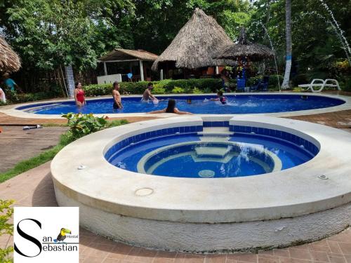 a pool at a resort with people in the water at Cabañas San Sebastian in Palomino
