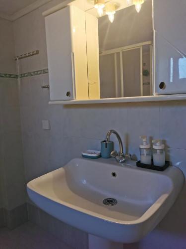 a white sink in a bathroom with a mirror at Evangelias House! in Stavros
