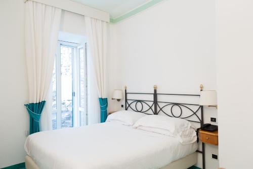 Postel nebo postele na pokoji v ubytování Grand Hotel Santa Domitilla