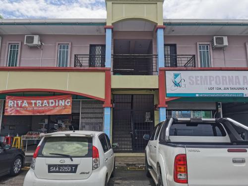 two cars parked in a parking lot in front of a building at Garden in Semporna