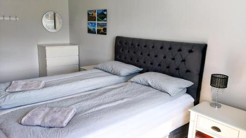 a bedroom with two beds with a black headboard at Apartment with Amazing Mountain View in Bolungarvík