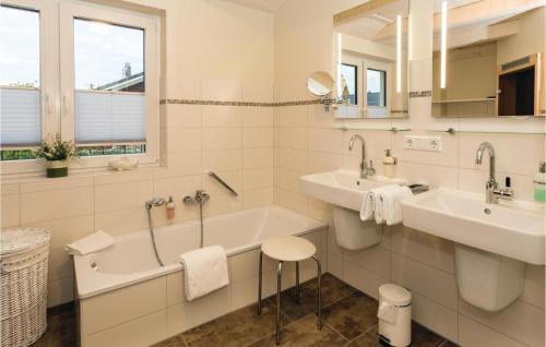 ein Badezimmer mit zwei Waschbecken, einer Badewanne und einem Waschbecken in der Unterkunft Stunning Home In Dagebll With 2 Bedrooms, Sauna And Wifi in Dagebüll