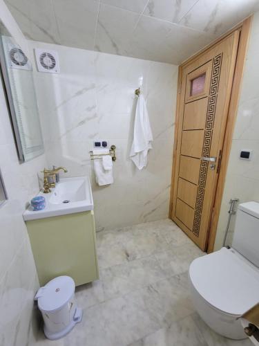 a white bathroom with a toilet and a sink at ZR Comfort Delux in Fez