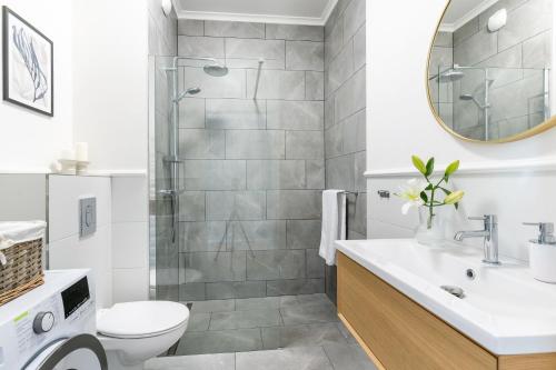 a bathroom with a shower and a toilet and a sink at UKIEL PARK 20 - Apartament Superior 2 sypialnie przy Plaży Miejskiej in Olsztyn