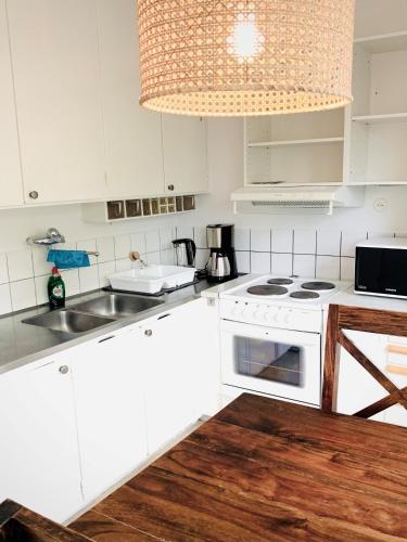 una cocina con armarios blancos y un horno de fogón blanco en Gamla Järnvägsgatan 6 en Bollnäs