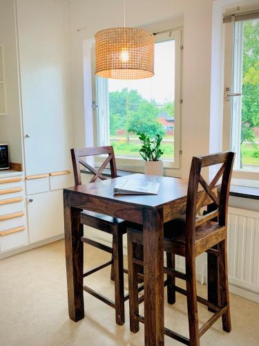 a dining room table with two chairs and a chandelier at Gamla Järnvägsgatan 6 in Bollnäs