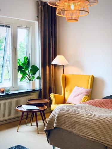 una camera con un letto, una sedia gialla e una finestra di Gamla Järnvägsgatan 6 a Bollnäs