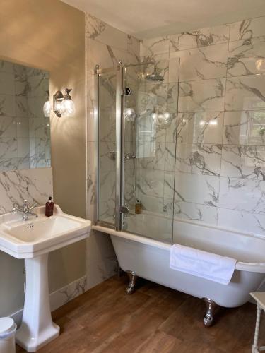 a bathroom with a shower and a tub and a sink at Bedrule Old Manse B&B in Hawick