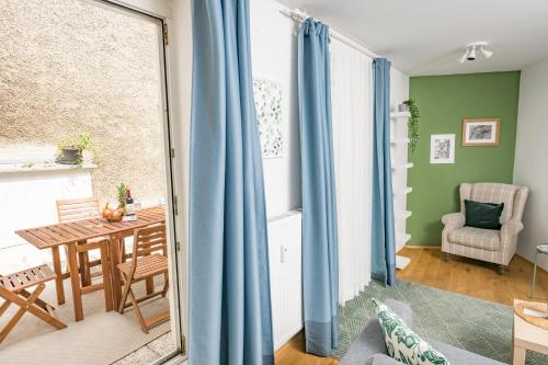 a living room with blue curtains and a table at Zum Grazer Uhrturm in Graz