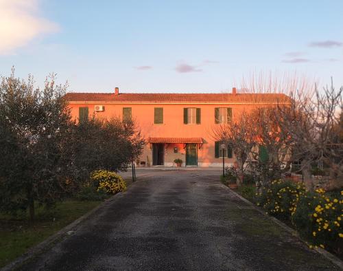 an orange building with a road in front of it at Eco House San Michele in San Michele
