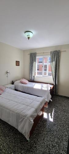 2 camas en un dormitorio con ventana en SOYSOL.DEPARTAMENTOS B° CIudad de Nieva en San Salvador de Jujuy