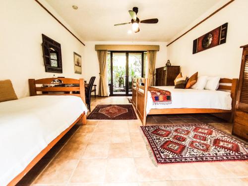 a bedroom with two beds and a desk at La Buena Vibra Retreat and Spa Hotel in Tepoztlán