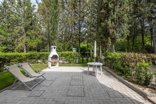 a patio with two chairs and a table in a park at Podere Mezzastrada - Place of Charme in Fiano